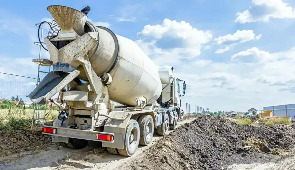 A 10-yard concrete truck at a construction site with dirt piles in the background.