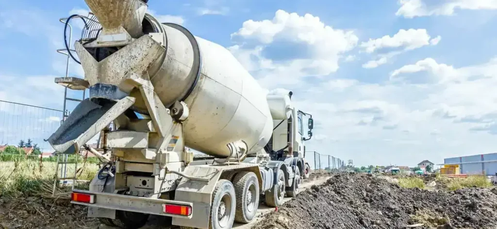 A 10-yard concrete truck at a construction site with dirt piles in the background.