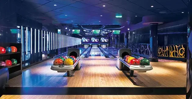 Modern bowling alley with colorful bowling balls and lanes.