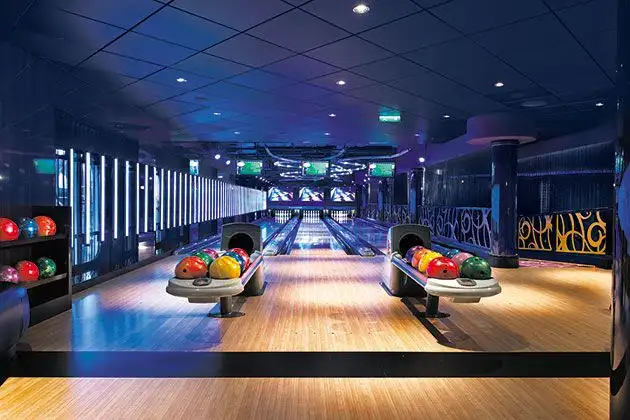 Modern bowling alley with colorful bowling balls and lanes.