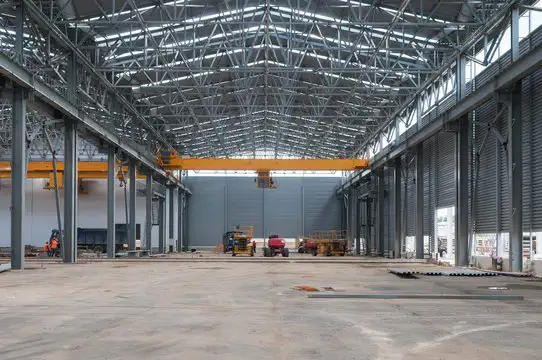 A 5,000 sq ft warehouse with steel beams and a crane, showcasing a sturdy industrial setup.