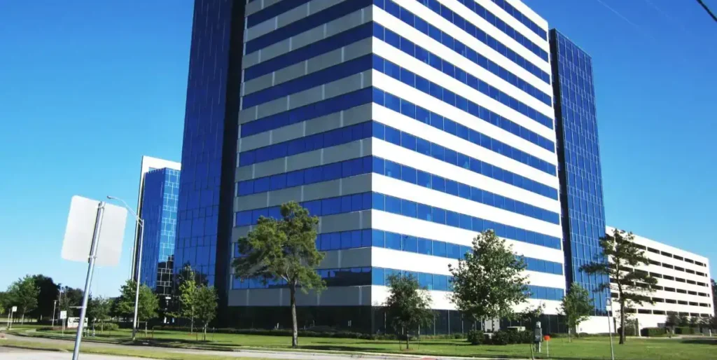 Modern commercial building with glass facade under a clear blue sky.