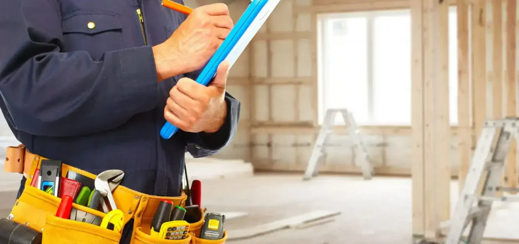 Plumbing contractor taking notes at a construction site with a tool belt.